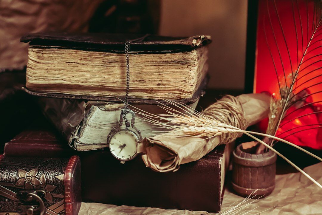 Stack of old leather-bound books with a magnifying glass on top
